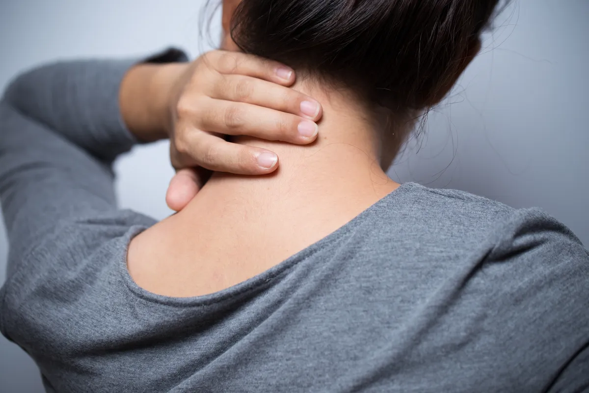  a woman with her hand on her neck