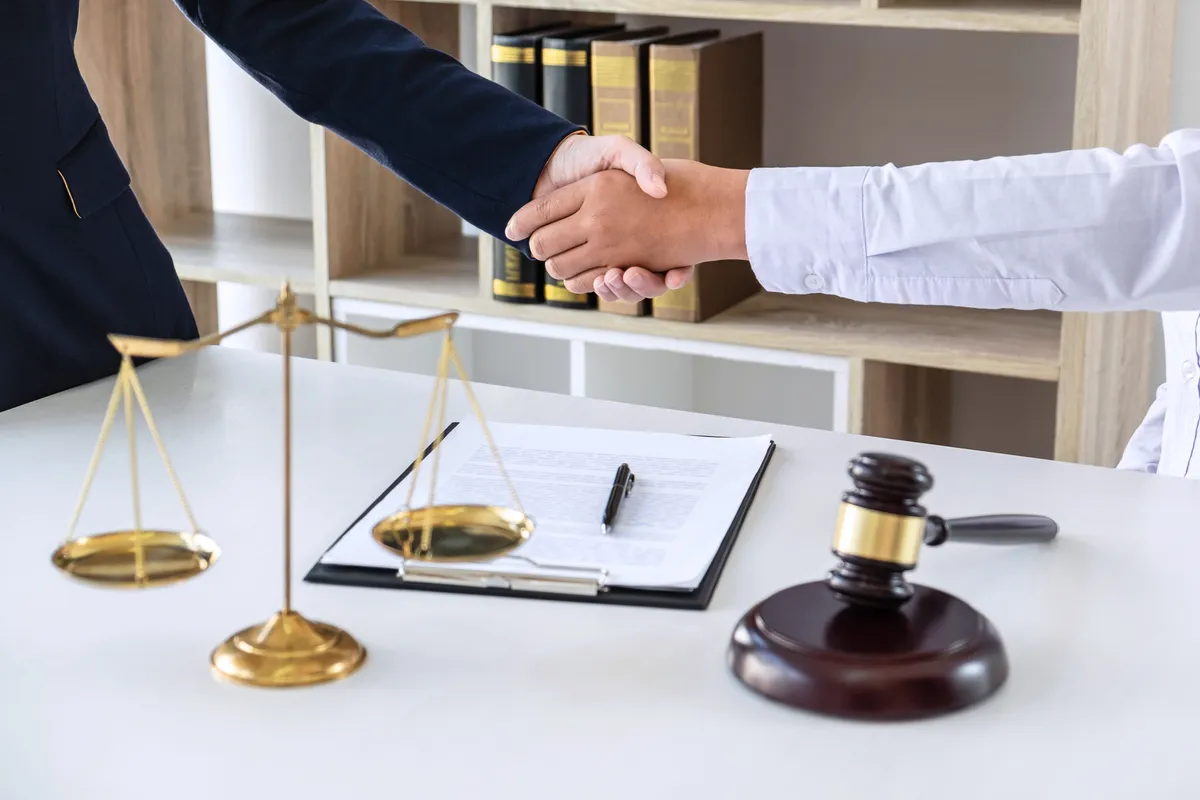 Image of an attorney shaking a client's hand