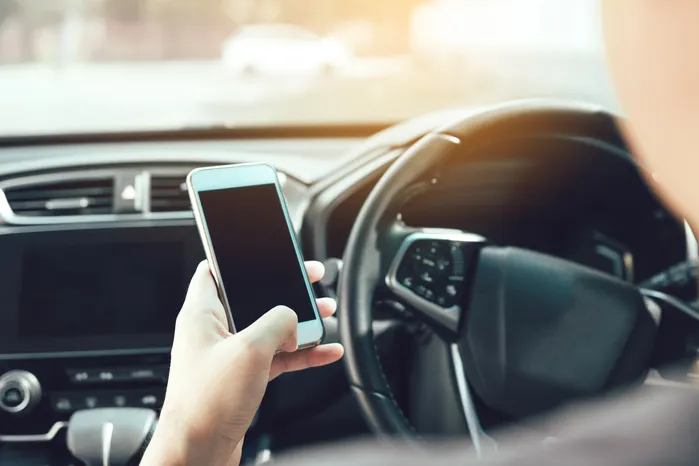 man using a rideshare app in a car