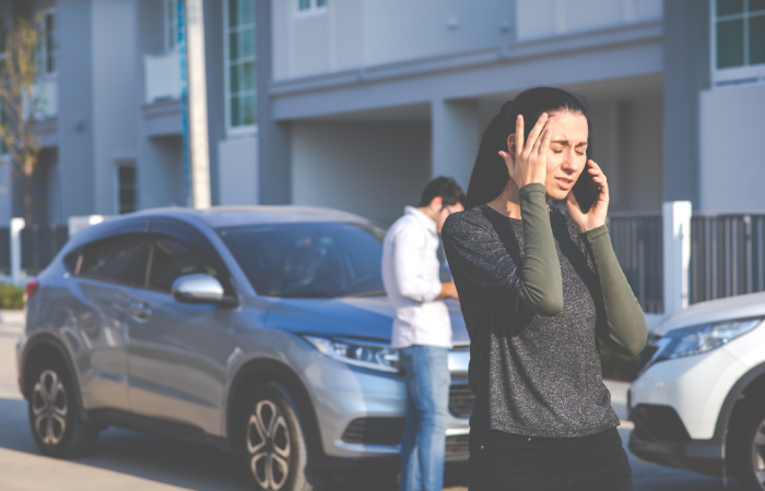 A Women on the phone talking to a Paradise car accident lawyer after a car accident.