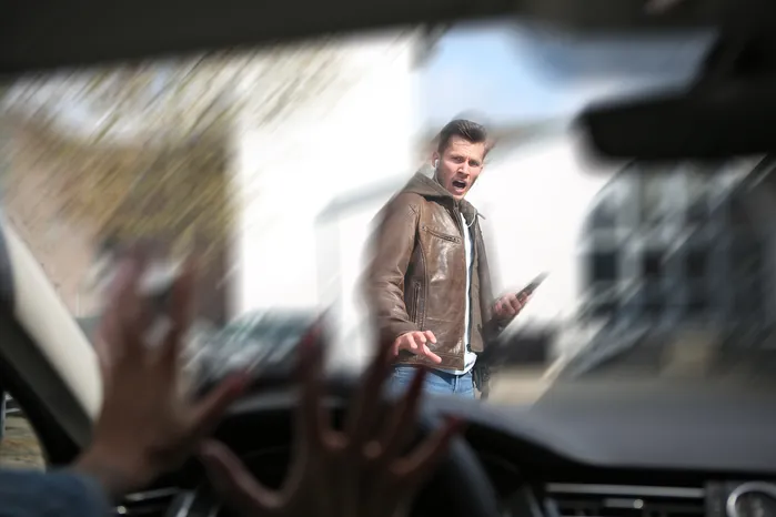 pedestrain crossing the road telling a car to stop