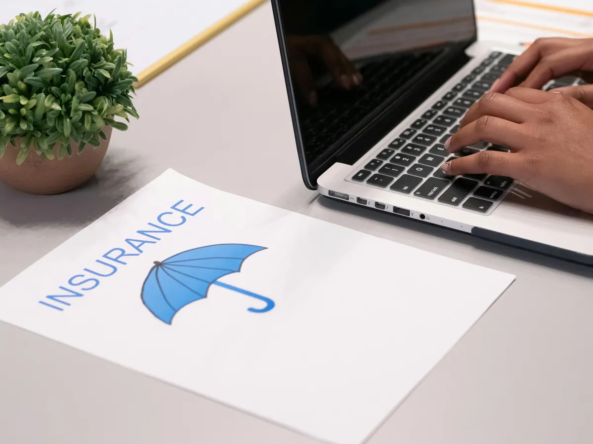 someone is typing on a laptop with an umbrella on the screen