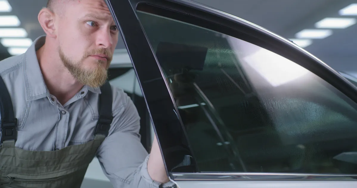 Mechanic applying a window tint