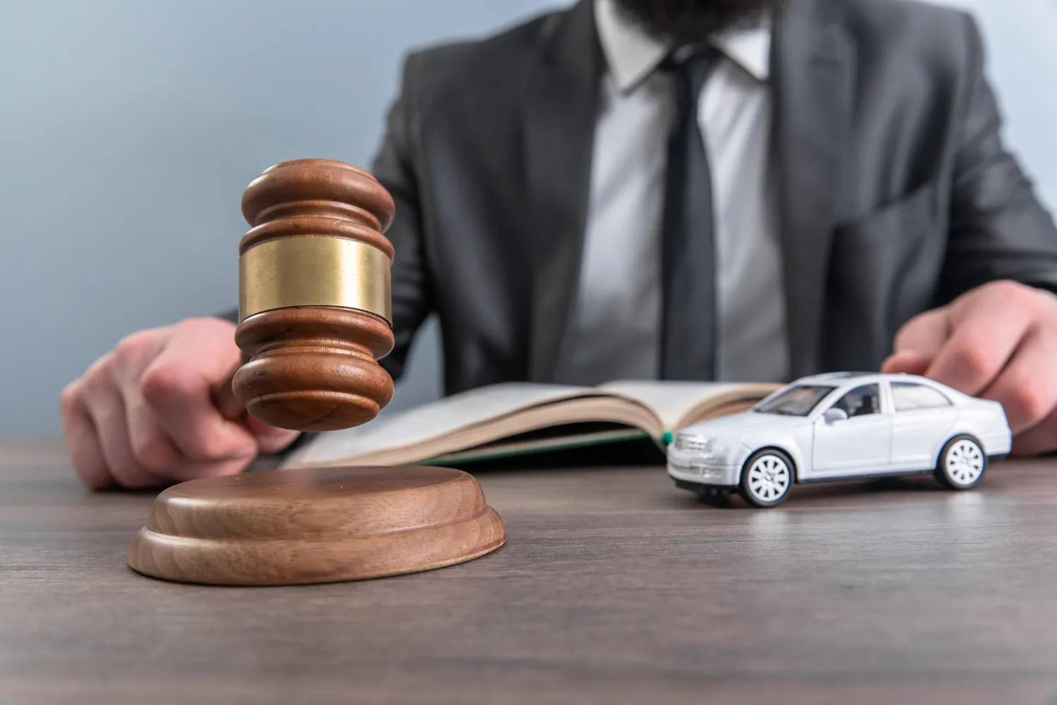 Image of a car accident lawyer holding a prop car