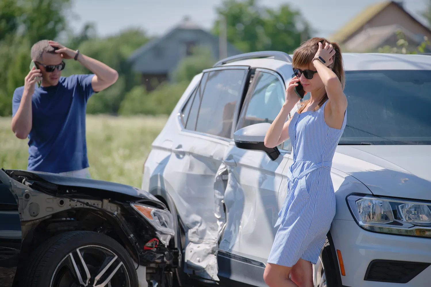 Two people on their phones after a T-bone car accident