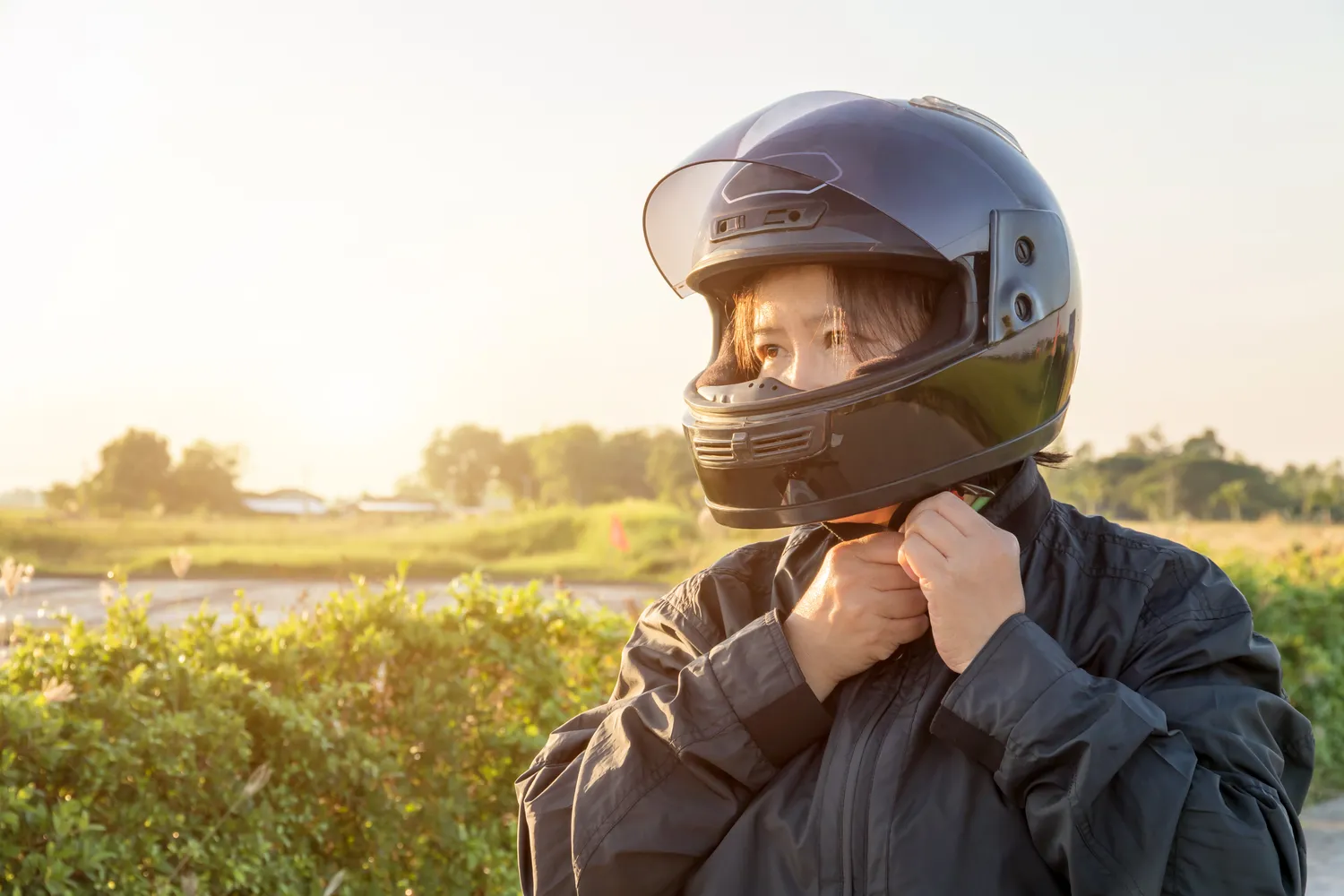 A female putting on a motorcycle helmet